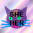 My main avatar, but with the words "SHE HER" on my face in a sans serif font.  Since the words are black and my face is dark purple, they're a bit hard to read.