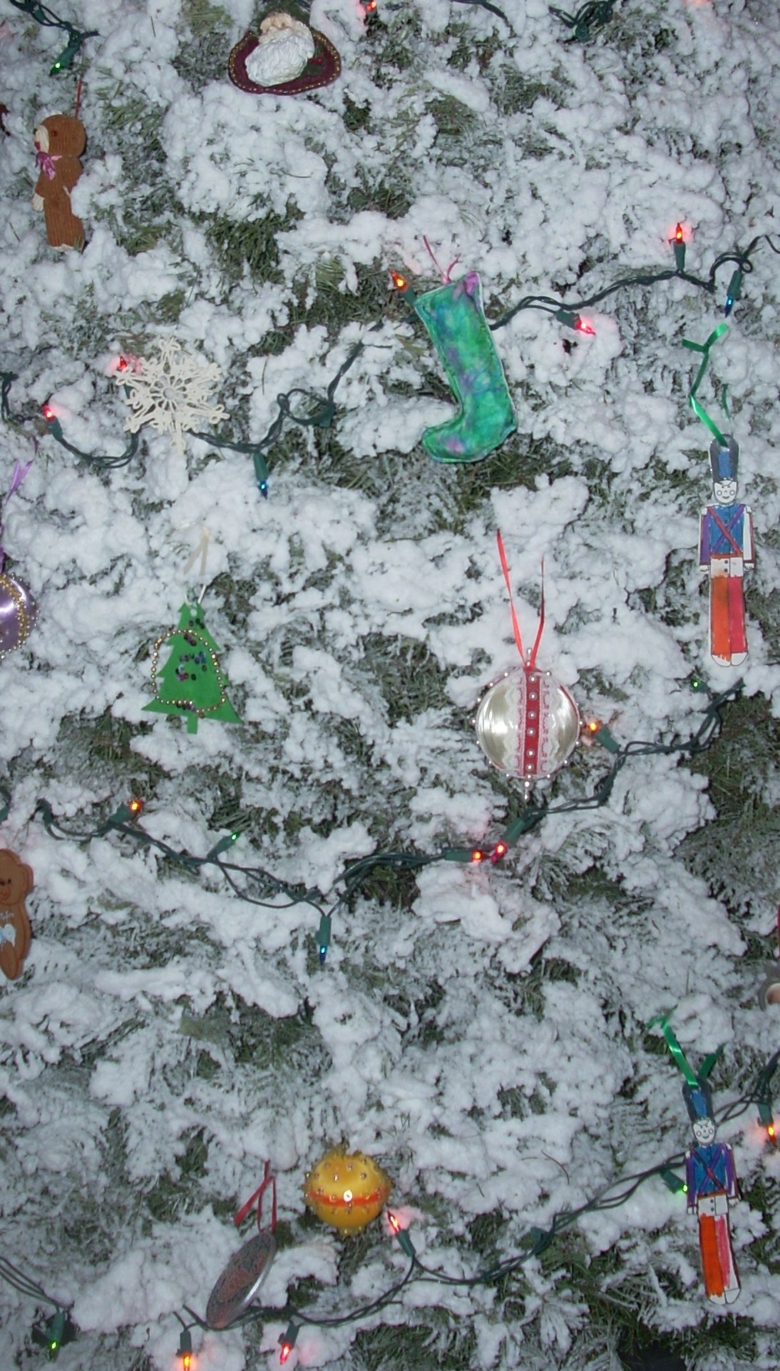A tree with white stuff on it and various ornaments 