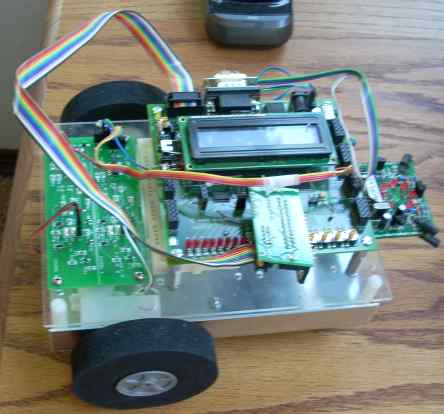 Inside view, showing many circuit board thingies, a rainbow-colored cord, two wheels, and an LCD panel.